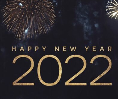 Happy New Year 2022 Text Holiday Graphic with Gold Fireworks Background in Night Sky